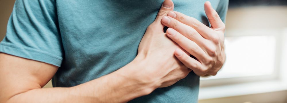 man gripping chest with both hands